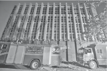  ?? — Gambar Reuters ?? TERBAKAR: Trak bomba dilihat di hadapan sebuah hospital selepas ia terbakar di bandar pinggir Mumbai, India, pada Isnin.