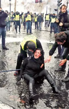  ?? EFE ?? Una manifestan­te es socorrida, el sábado pasado.