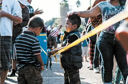  ?? GUILLERMO ARIAS/GETTY-AFP ?? Central American migrants wait at the U.S.-Mexico border in Tijuana. The U.S. is seeking a solution to the border crisis.