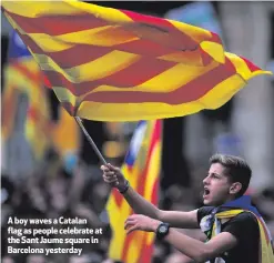  ??  ?? A boy waves a Catalan flag as people celebrate at the Sant Jaume square in Barcelona yesterday