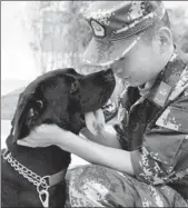  ?? QIU XIAOPING / FOR CHINA DAILY ?? A sniffer dog with its handler at the dog-training base of the Heilongjia­ng provincial border defense troops in Harbin.