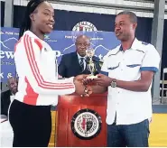  ??  ?? Ikeka Binns of the University of the West Indies, who broke the open discus and shot put records at the JC/Purewater-Danny Williams meet with throws of 55.00 and 14.48 metres, respective­ly, collects her award for being the top athlete in the open...