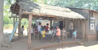  ??  ?? Los niños indígenas reciben enseñanza bajo un galpón con techo de paja.