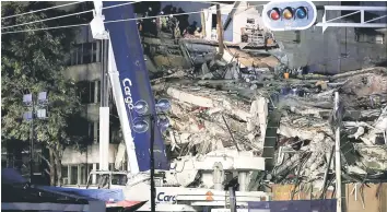  ??  ?? Members of rescue teams work in the rubble of a collapsed building. — Reuters photo