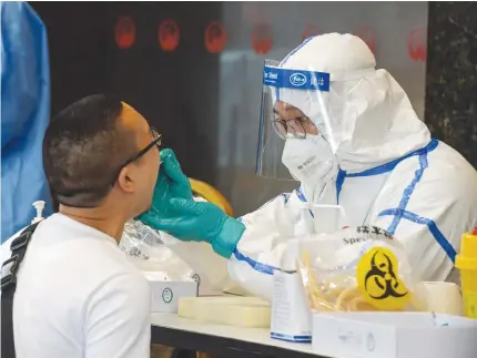 ?? PHOTO BY STR / AFP / CHINA OUT ?? SWABBED
A man, who visited Beijing recently, is tested for the coronaviru­s in Nanjing in China’s eastern Jiangsu province on June 15, 2020.
