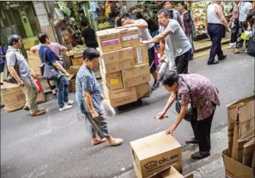  ?? LAM YIK FEI/THE NEW YORK TIMES ?? A woman breaks down a cardboard box for recycling in Hong Kong on October 13.