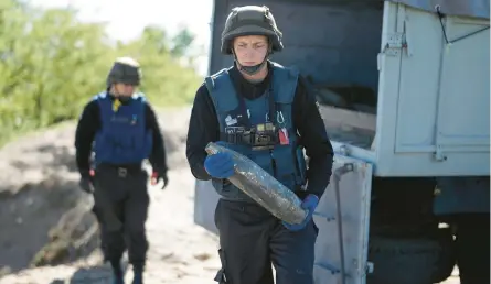  ?? CHRISTOPHE­R FURLONG/GETTY ?? Members of a bomb disposal unit in the Ukrainian State Emergency Service prepare for a controlled demolition of Russian munitions that were recovered during a demining operation Friday near Borodianka.