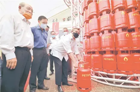  ?? — Photo by Chimon Upon ?? Abang Johari gestures at a Petros LPG cylinder as Hamid (le ), Dr Rundi (second le ) and others look on.