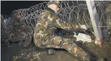  ?? GYORGY VARGA/ MTI VIA AP ?? Hungarian soldiers erect a fence between Croatia and Hungary Saturday. Critics accuse Prime Minister Viktor Orban of escalating the immigratio­n crisis to pander to xenophobic voters.