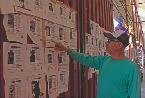  ?? MELANIE TORRES ?? En el interior del mercado Venustiano Carranza, un hombre observa un “muro” con decenas de boletines de búsqueda.