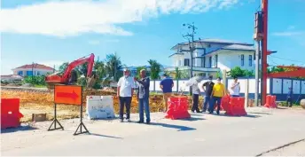  ??  ?? Ting (left) inspects the works progress of the Ulu Sungai Merah traffic-light junction project.