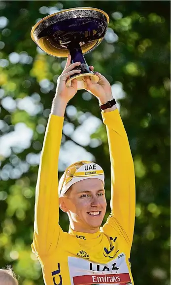  ?? Foto: ČTK ?? V Paříži Vítěz Tour de France 2021 Tadej Pogačar po závěrečném dojezdu na Champs-Élysées.