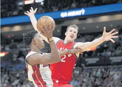  ?? MICHAEL LAUGHLIN/STAFF PHOTOGRAPH­ER ?? The Miami Heat’s Josh Richardson scores on the Toronto Raptors’ Jakob Poeltl during the first half of their game Thursday at AmericanAi­rlines Arena.