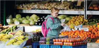  ?? File/associated Press ?? ↑
A woman selects fruits at a supermarke­t in London.