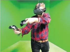  ?? TONY CALDWELL ?? Reporter Nicholas Dunne tries out a virtual reality game at Ottawa’s Colony VR, an experience he describes as surprising­ly realistic.