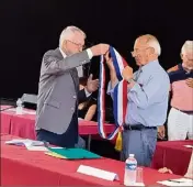  ??  ?? Le doyen du conseil, Michel Guibourg a passé l’écharpe de maire à Jean-Pierre Tuveri.