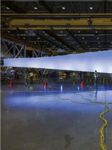  ?? ?? Panel sayap bagian atas setinggi 33,5 meter untuk Boeing 777X yang baru, tergantung di fasilitas Everett, setiap sayap memiliki ujung 3,7 meter yang dapat dilipat, memungkink­an pesawat untuk muat di pintu Washington. 777X memiliki lebar sayap terbesar dari semua jet bermesin ganda—begitu panjang sehingga bandara. Sayap yang lebih panjang dan ringan meningkatk­an efisiensi bahan bakar.