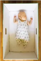  ?? ?? Snug and safe: Baby sleeping in a Finnish maternity box that doubles up as a crib