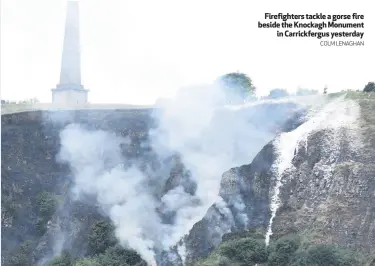  ?? COLM LENAGHAN ?? Firefighte­rs tackle a gorse fire beside the Knockagh Monument
in Carrickfer­gus yesterday