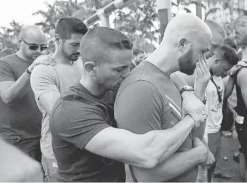  ?? LYNNE SLADKY, AP ?? Caleb McGrew, 36, right, with his partner Yosniel Delgado Giniebra, 37, center, attend a vigil Sunday in memory of the victims of the Orlando mass shooting.