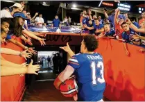  ?? SAM GREENWOOD / GETTY IMAGES ?? Florida quarterbac­k Feleipe Franks throws a wrist band to a fan after a victory over Charleston Southern on Saturday night. Franks threw for five touchdowns in the first half.