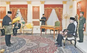  ?? — Gambar Bernama ?? WATIKAH: Sultan Nazrin mendengar watikah perisytiha­ran menjalanka­n tanggungja­wab sebagai Yang di-Pertuan Agong, yang dibacakan Dr Mahathir (kiri) pada satu istiadat di Istana Hinggap Perak dekat Kuala Lumpur, semalam.