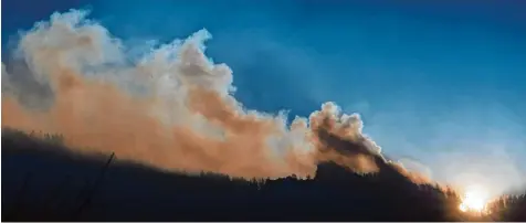  ?? Foto: Peter Kneffel, dpa ?? Die riesige Rauchsäule über dem Jochberg bei Kochel am See war aus zehn Kilometer Entfernung zu sehen. Verursacht haben den Flächenbra­nd wahrschein­lich zwei Berg wanderer aus München.