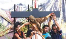  ??  ?? HOLY WEEK PREPARATIO­NS – These residents of Makati carefully handle the image of the crucified Jesus Christ Wednesday as part of their preparatio­n for the coming days of Holy Week. For today, Catholic devotees are expected to go on “Visita Iglesia,” or the tradition of visiting seven churches on Maundy Thursday. (KJ Rosales)