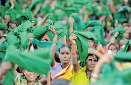  ?? MANJUNATH KIRAN/ AFP/ GETTY IMAGES FILES ?? Women spin green shawls above their heads to express unity during a rally to protest government corruption, in Bangalore, India.