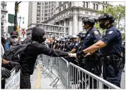  ?? AP ?? A protester fist-bumps with a police officer near New York City’s Foley Square during a protest Tuesday.