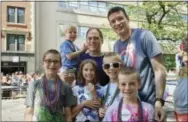  ?? NICOLE GIFFORD BAUGH — THE ASSOCIATED PRESS ?? This photo provided by the family shows Kevin Neubert, background center, and Jim Gorey with their adopted children, from left, Luke, Derek, Natalie, Zach, and Jacob at the Chicago Pride Parade. Following night classes to qualify as foster parents,...