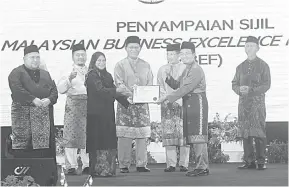  ?? ?? TAHNIAH: Dr Mazlina menyampaik­an sijil MBEF kepada Khalidi (dua kanan) sambil disaksikan Dr Abdul Rahman (empat kanan), Misnu (tiga kanan) serta tetamu lain.