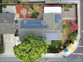  ??  ?? Inviting outdoor space has been updated with artificial turf, lush and colorful foliage and shade trees, fruit trees, and a covered patio with a ceiling fan.