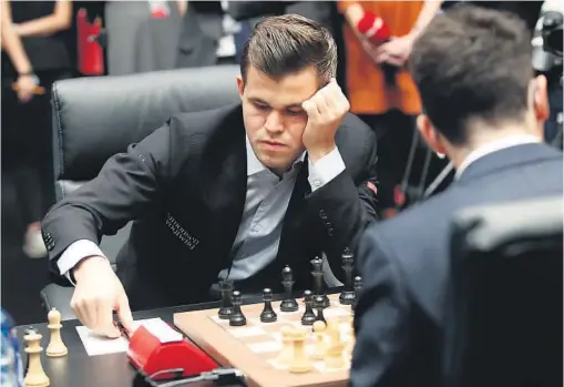  ?? FOTO: TERJE BENDIKSBY, NTB SCANPIX ?? REMIS: Magnus Carlsen i aksjon mot Fabiano Caruana. Også mandagens tredje parti endte med remis, og dermed er det 1,5-1,5 i kampen om VM-tittelen.