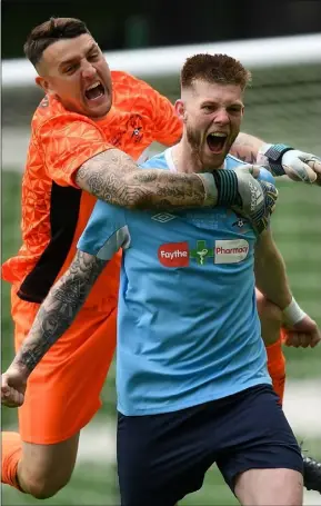  ??  ?? Goalkeeper Lee Walker is the first colleague to reach Gary Delaney after the ice-cool centre-half scored the winning goal in Saturday’s penalty shoot-out.