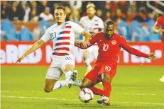  ?? COLE BURSTON/THE CANADIAN PRESS ?? Canada’s Junior Hoilett beats Aaron Long of the U.S. to the ball during their Nations League match in Toronto on Tuesday. Canada beat the U.S. for the first time since 1985.