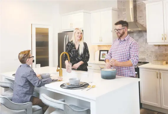  ?? CHRISTINA RYAN ?? Mark and Rachelle Cooper, with son Gavin, 10, look forward to the move to their new Wolf Willow home, where the modern kitchen with its big pantry is a highlight.