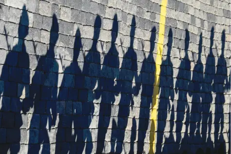  ?? — AFP ?? Sunday. Russian servicemen cast shadows on paving stones at Red Square as they take part in a rehearsal for the Victory Day military parade in Moscow on