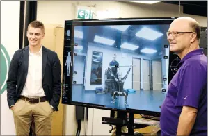  ?? NEWS PHOTO EMMA BENNETT ?? Cam Robinson and David Schnare watch Dr. Ryan Comeau and Maggie McLeod (seen on the TV monitor) as they work together Tuesday. Local company Kinetisens­e has been nominated for the 2018 Alberta Business Awards of Distinctio­n for the Export Award of...