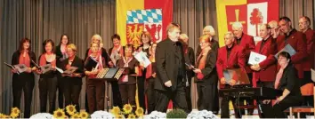  ?? Foto: Hieronymus Schneider ?? Siegfried Lauter dirigiert den Obermeitin­ger Singkreis, Silvia Landherr (rechts) begleitet am Klavier und der Vorsitzend­e Gottfried Riedmiller (dahinter) singt selbst mit.