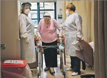  ?? Dania Maxwell Los Angeles Times ?? NORA HOVASAPYAN, left, and Zovinar Bolkorkian help resident Shake Godjamania­n at a skilled nursing facility in Mission Hills. The CDC says 17% of the vaccine doses sent to such facilities have been injected.