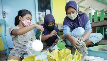  ?? ALFIAN RIZAL/JAWA POS ?? PROSPEK BAGUS: Untuk membuat satu pot tanaman, dibutuhkan 2–3 popok. Setiap bulan warga memproduks­i 30–40 pot. Bahan bakunya dari popok bekas balita di wilayah RW 2. Foto kiri, warga mengolah sampah daun menjadi arang.