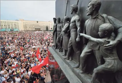  ?? Associated Press photos ?? Belarusian opposition supporters gather for a protest Tuesday in front of the government building at Independen­t Square in Minsk, Belarus, with a Soviet era sculptures in the foreground. The Telegram messaging app has become an indispensa­ble tool in coordinati­ng the unpreceden­ted mass protests that have rocked Belarus since Aug. 9, when election officials announced President Alexander Lukashenko had won a landslide victory to extend his 26-year rule in a vote widely seen as rigged.