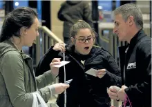  ?? JESSICA NYZNIK/EXAMINER ?? Hannah Woodside, left, and Grace Bulman react to receiving a free $10 gift card to Lansdowne Place from Jeff Chartier, Peterborou­gh Police Associatio­n president. The associatio­n handed out 100 gift cards at the mall Monday to help spread holiday cheer.