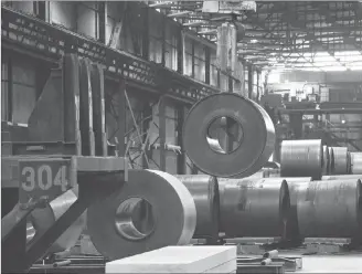  ?? CP PHOTO ?? A coils of steel is moved by a crane at the Direct Strip Production Complex at Essar Steel Algoma in Sault Ste. Marie, Ont.