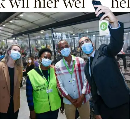  ?? FOTO PATRICK DE ROO ?? Staatssecr­etaris Sammy Mahdi neemt een selfie van enkele asielzoeke­rs die zich engageren als vrijwillig­ers op Spoor Oost. Links Antwerps schepen Els van Doesburg.