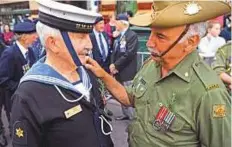  ?? AFP ?? Former sailor Bruce Joynes chats with former soldier Domenic D’Agostino before a march in Melbourne yesterday.