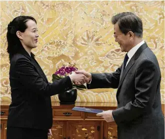  ?? Yonhap/AFP ?? Kim Yo-jong (esq.) entrega carta de seu irmão ao líder sul-coreano, Moon Jae-in, em Seul