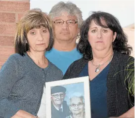  ?? CATHIE COWARD THE HAMILTON SPECTATOR ?? From left, Paula Rosati, Pat Caruso and Maria McChesney hold a photo of their parents, Michela and Giacchino (Jack) Caruso. Michela, 87, died in hospital of COVID-19, while Giacchino, 88, remains there. The family was told by public health that a personal support worker employed in their home tested positive for the disease.