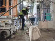  ??  ?? Damian Applegate shovels concrete at Bartlett High School as part of the $60 million renovation on Oct. 3. ARIEL COBBERT / THE COMMERCIAL APPEAL